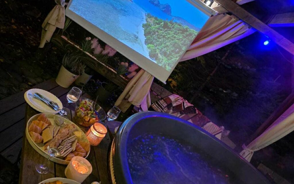 Wieczorne jacuzzi przy parterowym domku z ekranem projektora